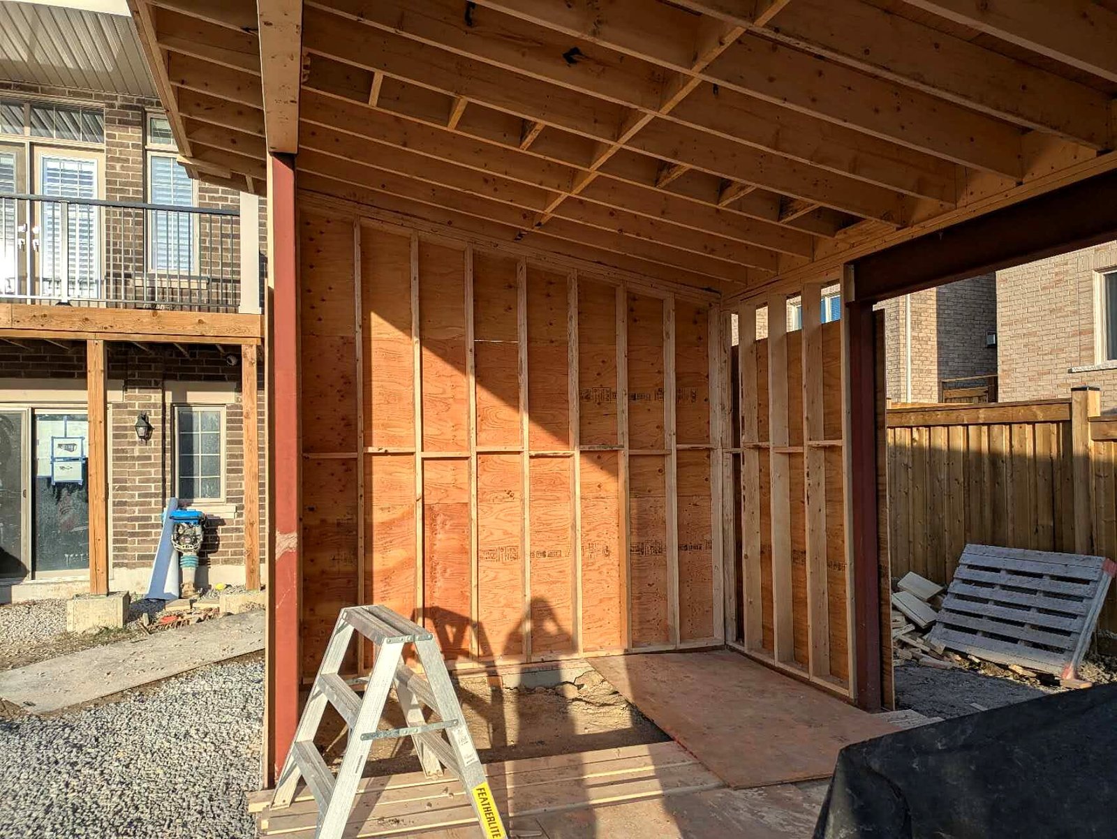 Pool cabana wall under construction beside a steel post